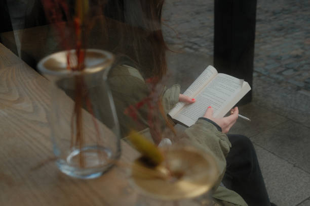 Young woman sitting in cafe reading a book