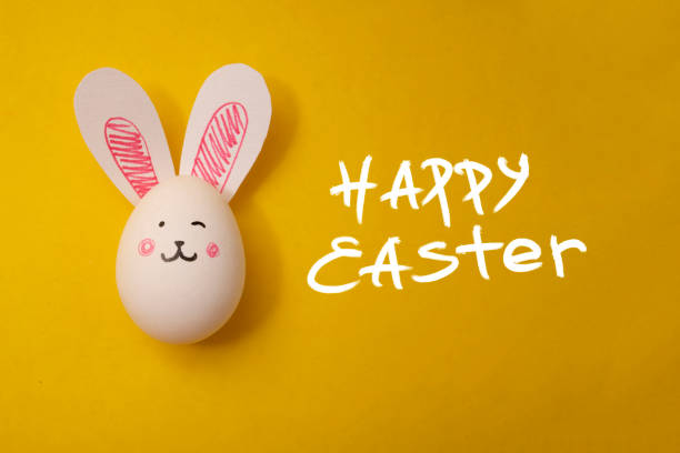 istock Greeting card with white text Happy Easter and chicken egg with cute rabbit face 2192878850