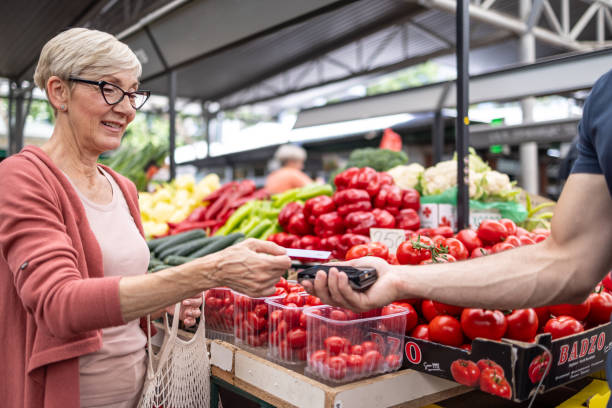 istock Woman paying for vegetables at a market 2192882585