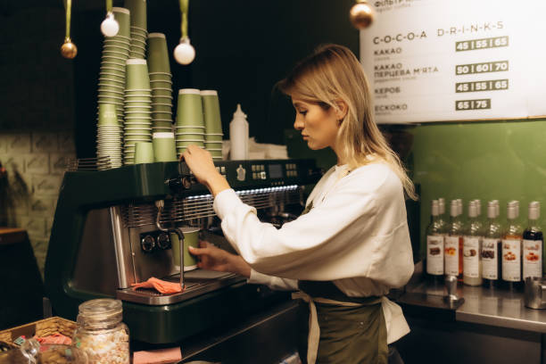 istock Young barista preparing coffee for customers at her cafe counter 2192883763