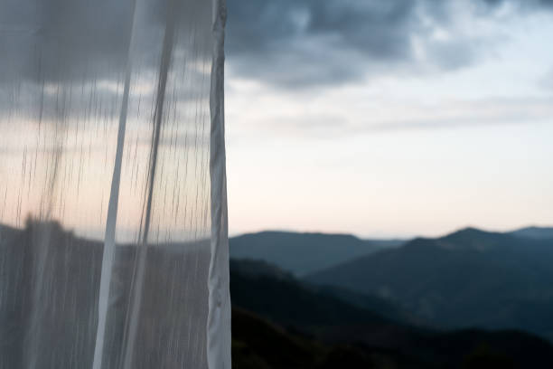 View seascape looking pass Translucent white fabric curtains and outdoor terrace Nan province mountains at Thailand
