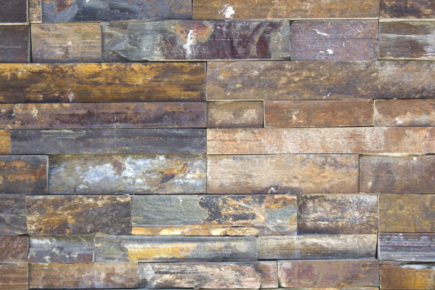 This wall is made of many rectangular stone slabs neatly stacked together. It is a beautiful background material that looks like an elaborate work of art.