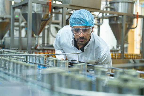 istock Professional closely examining production materials on a conveyor system, representing dedication to quality, precision, and modern technology in manufacturing processes. 2192901391