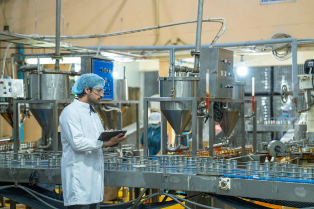 istock Professional closely examining production materials on a conveyor system, representing dedication to quality, precision, and modern technology in manufacturing processes. 2192901484