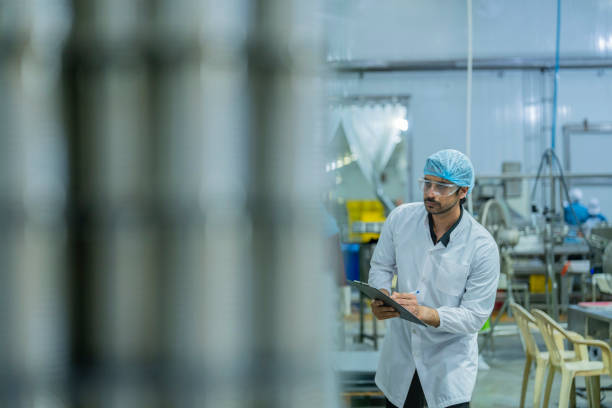 istock Industrial professional monitoring production processes with a clipboard, emphasizing precision, focus, and adherence to safety standards in a modern manufacturing environment. 2192902029