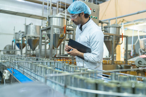 istock Professional closely examining production materials on a conveyor system, representing dedication to quality, precision, and modern technology in manufacturing processes. 2192902298