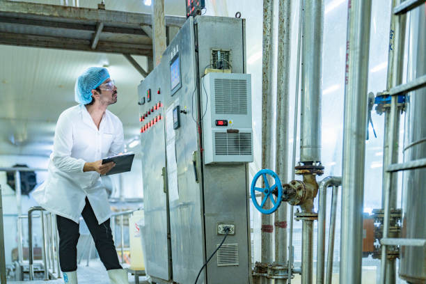 istock Factory technician inspecting an industrial tank with a clipboard, showcasing precision, quality control, and attention to detail in a modern manufacturing environment. 2192903326