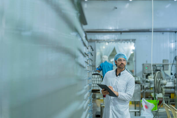 istock Industrial professional monitoring production processes with a clipboard, emphasizing precision, focus, and adherence to safety standards in a modern manufacturing environment. 2192903364