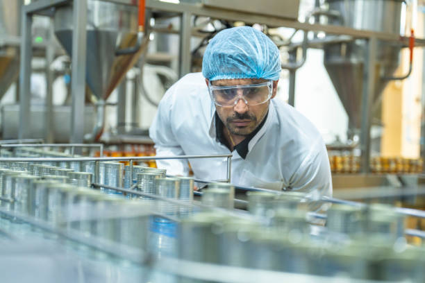 istock Professional closely examining production materials on a conveyor system, representing dedication to quality, precision, and modern technology in manufacturing processes. 2192903385