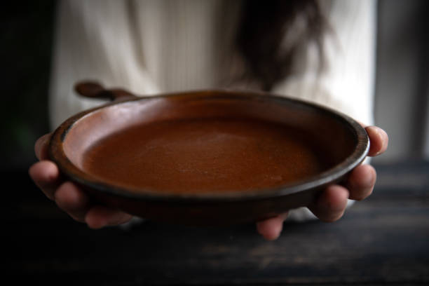 istock Woman holding a  plate with both hands on a dark wooden background 2192903616