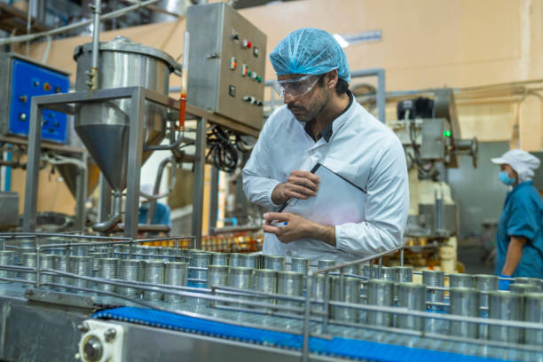 istock Professional closely examining production materials on a conveyor system, representing dedication to quality, precision, and modern technology in manufacturing processes. 2192903628