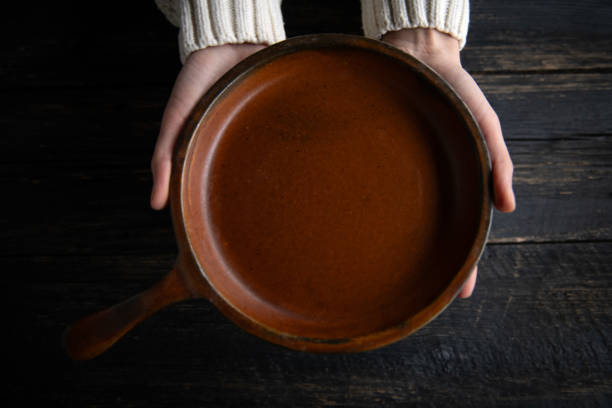 istock Woman hands holding plate over rustic wooden table. 2192903637