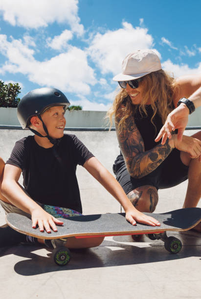 istock Skateboarding Dad teaching his son about skateboarding and enjoying some father and son time together 2192905885