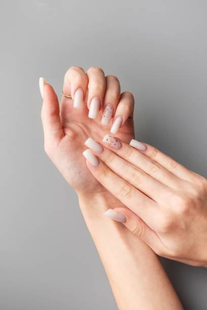 istock Woman showing stylish white nails with glitter on grey background 2192906617