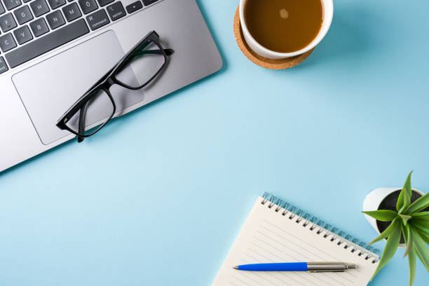 istock Coffee cup, laptop keyboard and notepad on blue office desk. Business office concept 2192907857
