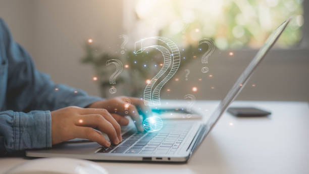 istock FAQ concept, ask questions, find answer online in customer support. Business man uses laptops to answer customer questions online, Q and A. Online service gives quick answers. 2192908519