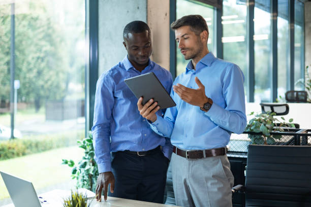 istock Two diverse business partners standing and discussing project working together at workspace 2192909351