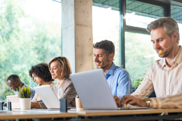 istock Portrait of call center worker accompanied by his team. Smiling customer support operator at work. 2192910050