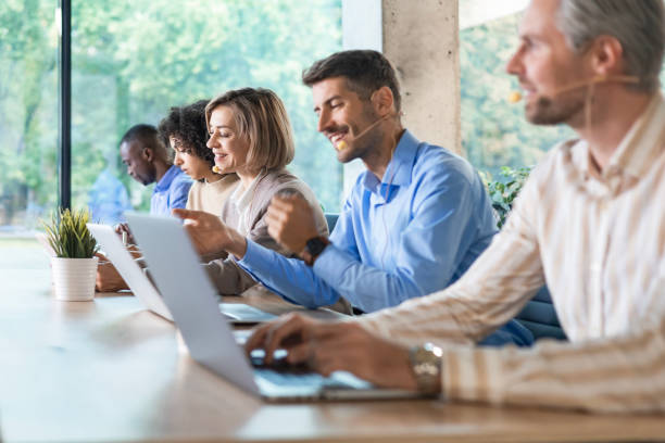 istock Portrait of call center worker accompanied by her team. Smiling customer support operator at work. 2192910084
