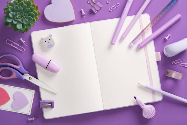 istock Open notepad and stationery, felt-tip pens, stapler, ruler, eraser, pins, clips in purple theme. Space for your text. 2192914248
