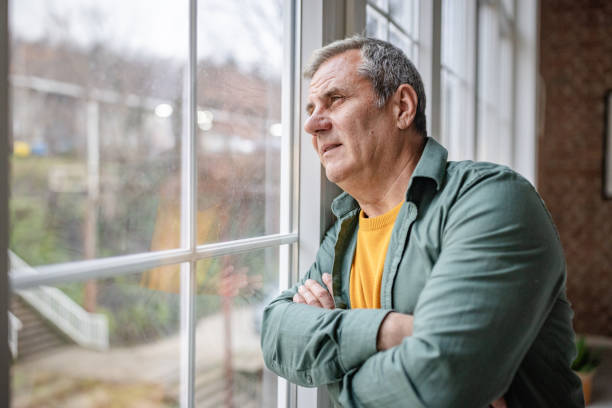 istock Close-up of a man looking through a window glass 2192917836