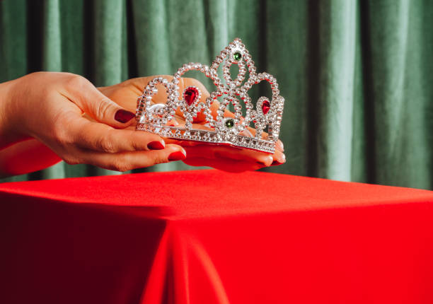 Female hands hold crown with precious stones