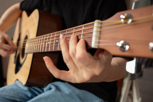 istock Hand Playing Acoustic Guitar Close-Up, concentration on fretboard, study of instrument, learning music 2192920582