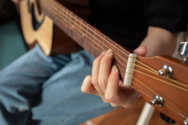 istock Hand Playing Acoustic Guitar Close-Up, performer practicing chords, strumming strings indoor 2192920585
