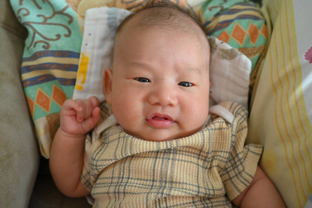 Portrait of a newborn Asian baby on the bed.
