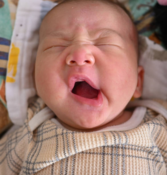 istock Sleeping beautiful baby boy 4 week old yawning on bed. 2192921787