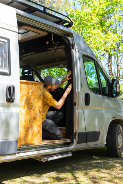 istock Campervan conversion: man installing mosquito net on door of his van 2192922537