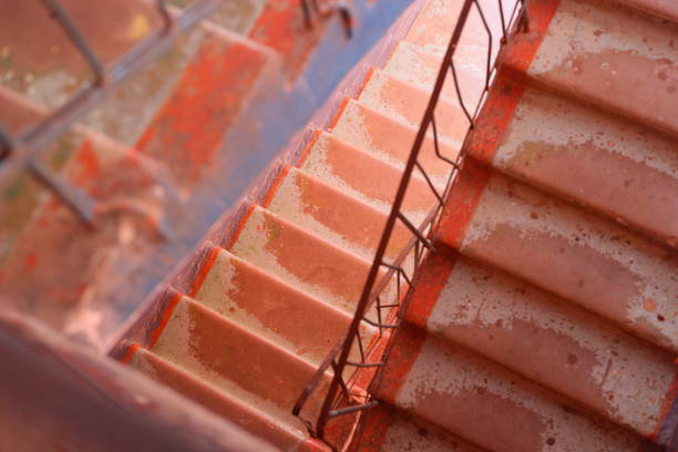 A captivating view of a beautifully designed spiral staircase featuring rustic tiles illuminated by natural light