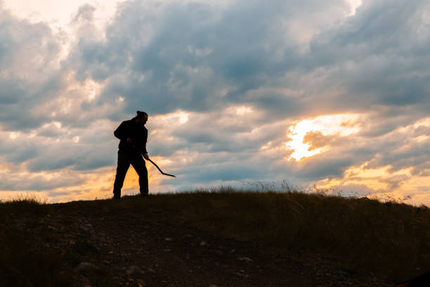 istock There is a man standing on a hill with a shovel in his hands 2192925453