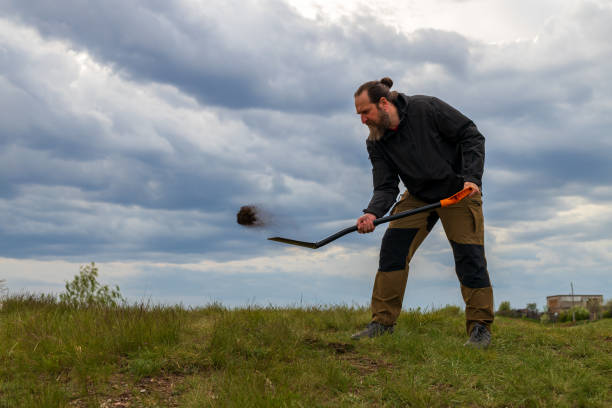 istock A man is digging in the grass with a shovel 2192925471
