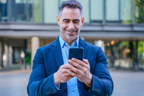 istock Confident businessman using smartphone outdoors 2192925622