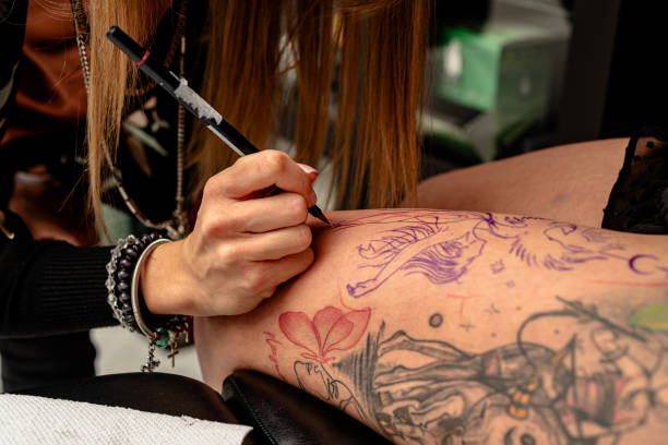 istock A tattoo artist creates intricate designs on a client's leg. 2192926525