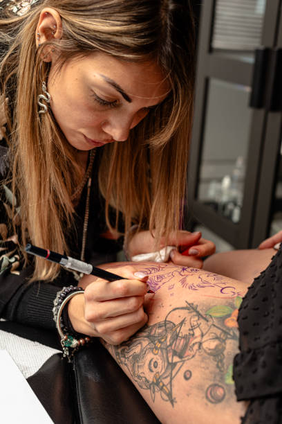 istock Female tattoo artist designing artwork on a client's arm in studio 2192927295