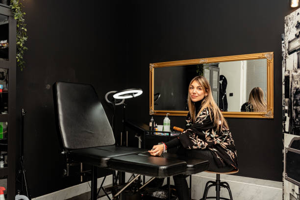 Confident female tattoo artist sitting in a studio with tools and equipment