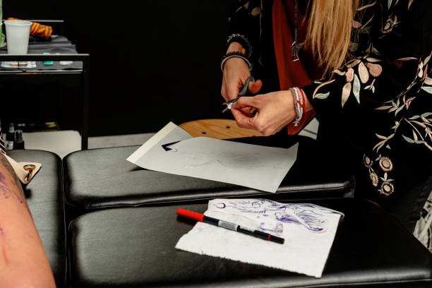 istock Tattoo artist preparing stencil design for application on client 2192927908