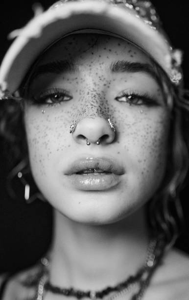 Portrait of a young woman with freckles and a baseball cap.