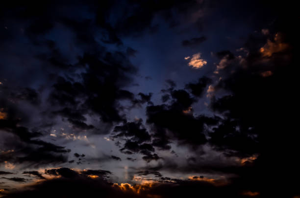 The sky is dark and cloudy with a few clouds in the distance. The clouds are white and the sky is blue