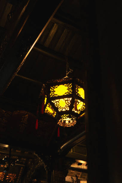 Hoi An, Vietnam. Traditional red lanterns under a heritage roof, glowing warmly in the sunlight, showcasing the beauty of cultural traditions and festive vibes.