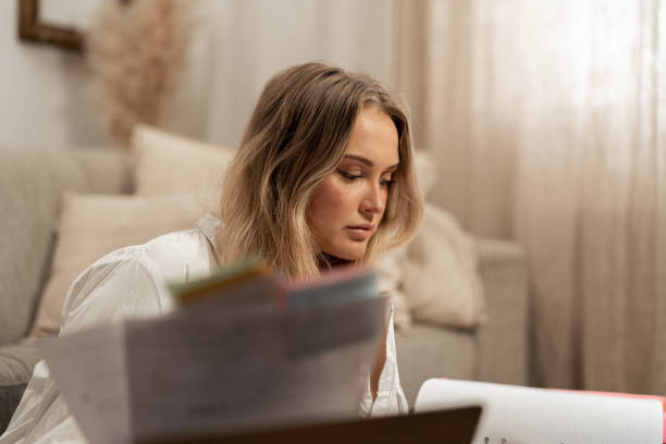 istock Beautiful blond woman reading financial documents while working from home 2192932362