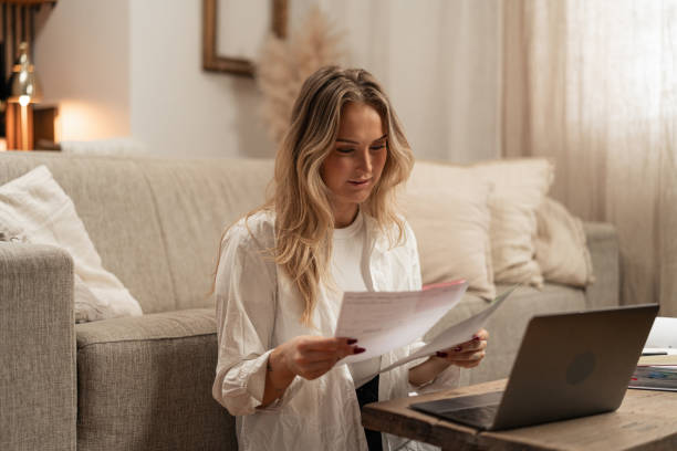 istock Confident woman reading financial documents at home 2192932363