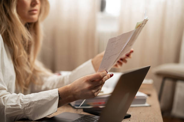 istock Woman analyzing financial documents with laptop in home office 2192932379