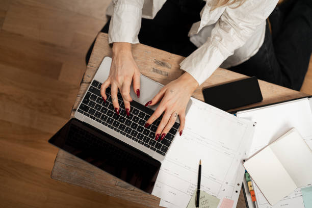 istock Woman working from home typing on laptop with financial documents at table 2192932382