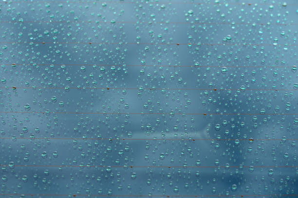 Droplets cling to glass, distorting the view of a moody sky while creating an atmosphere of serenity and introspection.