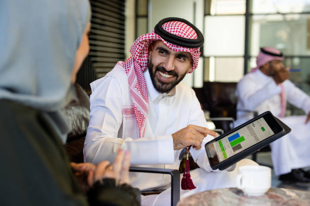 pengusaha dan kolega saudi mendiskusikan data di tablet digital di kafe - gamis foto potret stok, foto, & gambar bebas royalti
