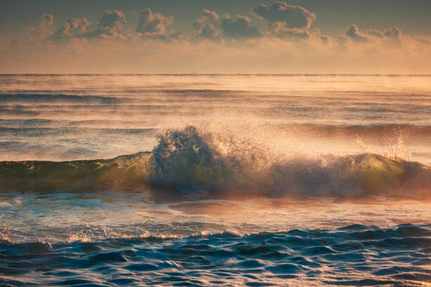 istock Golden Morning Waves on a Tranquil Sea During Sunrise with Soft sunlight and rays 2192933817