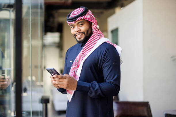 istock Young Saudi businessman in traditional attire using mobile phone 2192933846